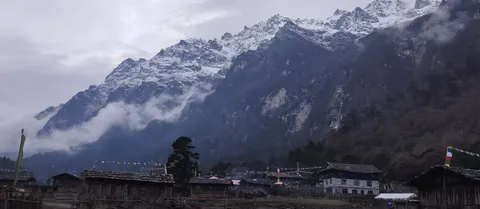 Fresh snow on the ridge above Ghunsa's wooden houses early on the morning we left for Khambachen