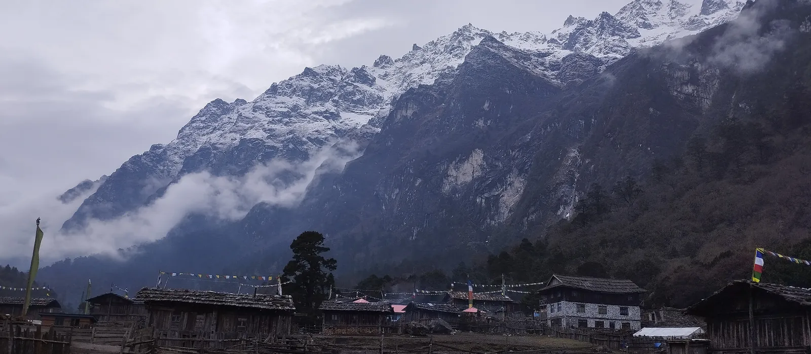 Fresh snow on the ridge above Ghunsa's wooden houses early on the morning we left for Khambachen