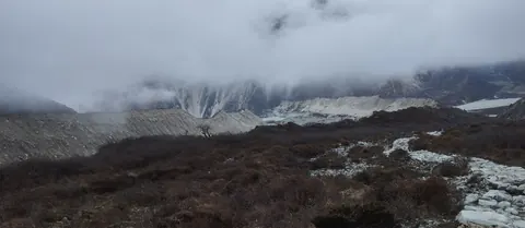 Grey moraine walls of the glacier under cloud at around 4,370m above Khambachen
