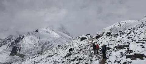 Trekkers on the snowy trail below Dharamsala