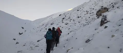 Trekkers climbing by first light toward the Larkya La