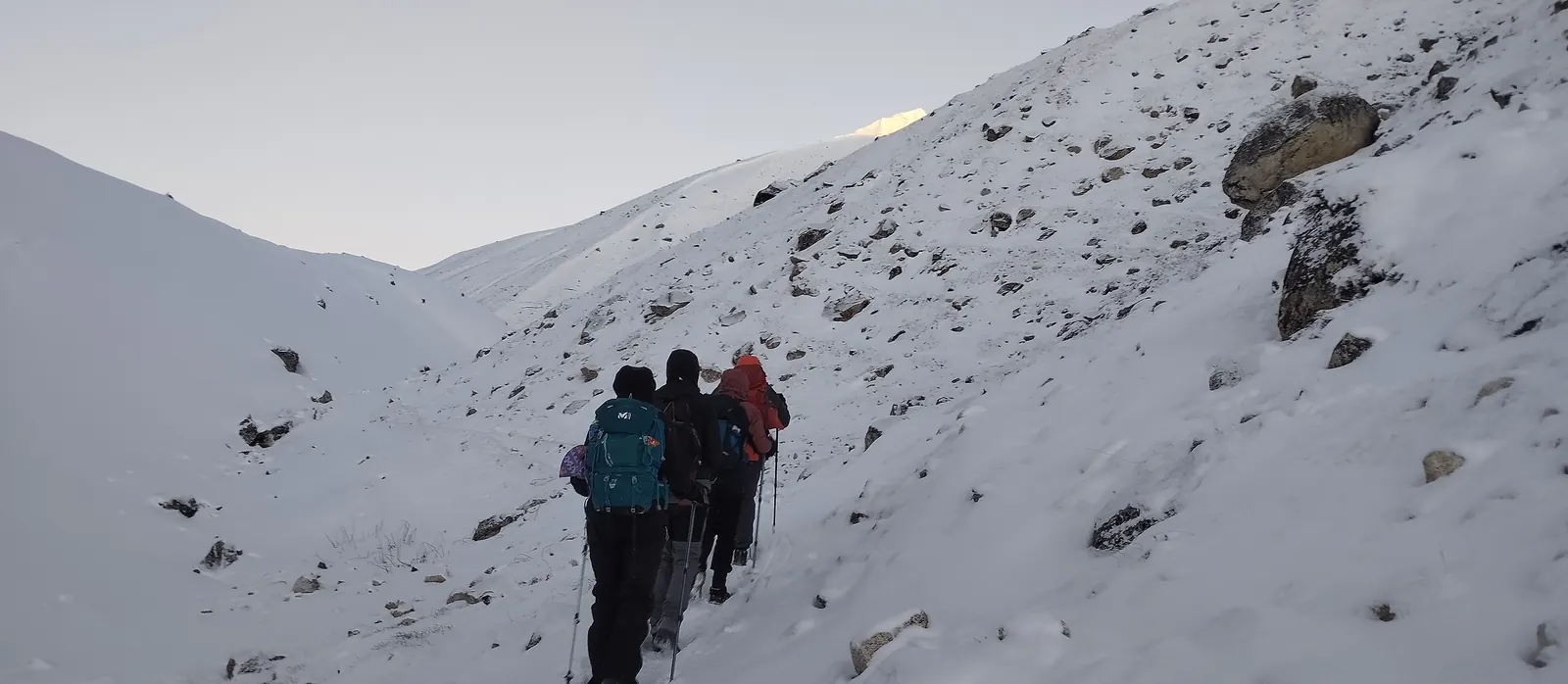 Trekkers climbing by first light toward the Larkya La