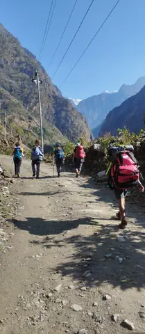 Trekkers walking the dirt road up the Budhi Gandaki valley above Machha Khola