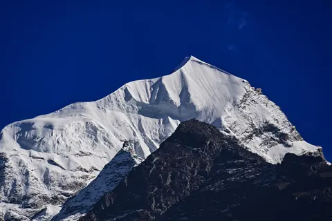 A snow-covered summit against a deep blue sky